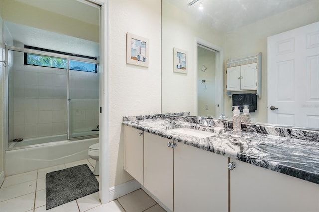 full bathroom with shower / bath combination with glass door, vanity, tile patterned floors, and toilet