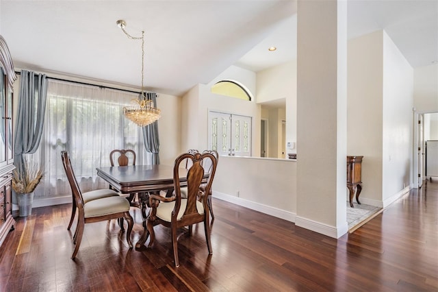 dining space with a notable chandelier, dark wood-type flooring, and high vaulted ceiling