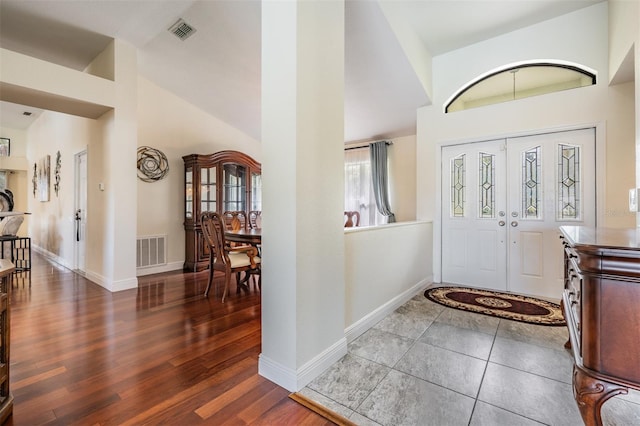 entryway with dark wood-type flooring and vaulted ceiling