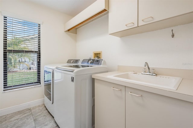 laundry room featuring cabinets, light tile patterned floors, separate washer and dryer, and sink