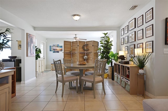 dining space with light tile patterned floors, a textured ceiling, and ceiling fan