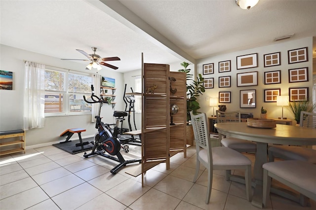 workout area featuring light tile patterned flooring, a textured ceiling, and ceiling fan