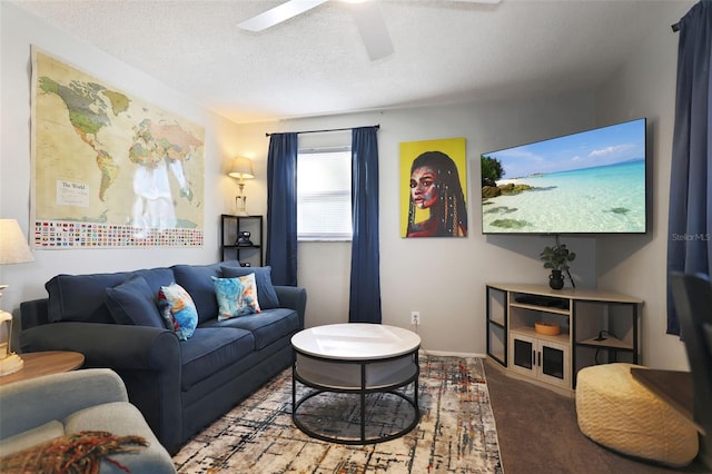 living room featuring ceiling fan, carpet flooring, and a textured ceiling