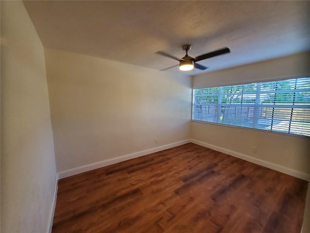 empty room featuring dark hardwood / wood-style flooring and ceiling fan