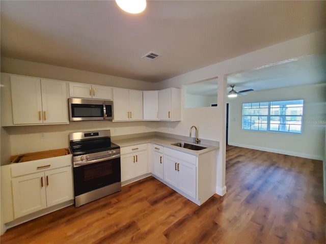 kitchen featuring sink, dark hardwood / wood-style floors, ceiling fan, appliances with stainless steel finishes, and white cabinetry