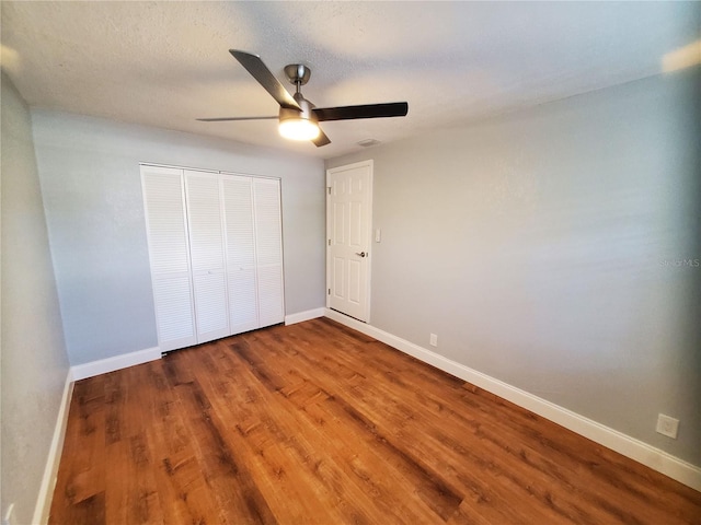 unfurnished bedroom featuring a closet, ceiling fan, and hardwood / wood-style flooring