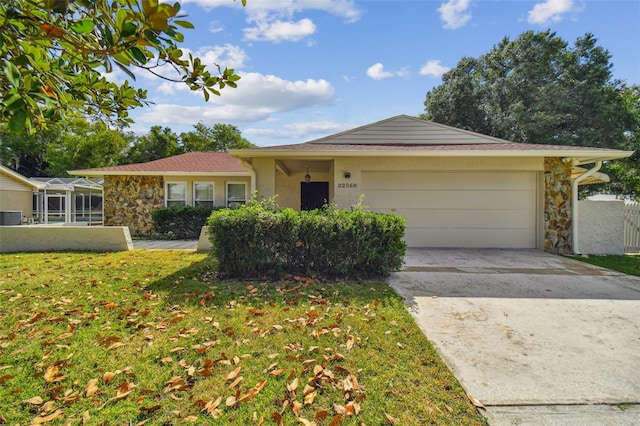 single story home featuring cooling unit, a front yard, and a garage