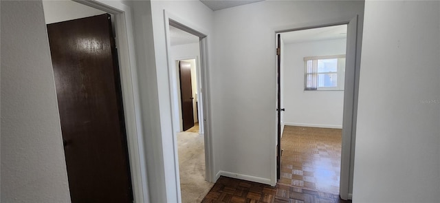 corridor featuring dark parquet flooring