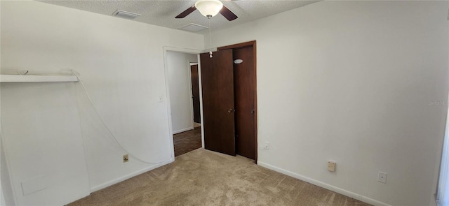 carpeted empty room featuring ceiling fan and a textured ceiling