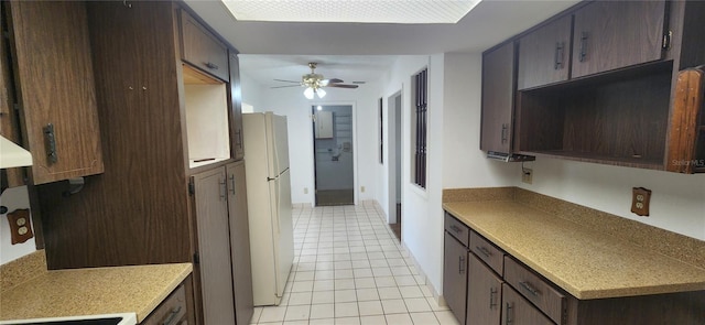 kitchen featuring white refrigerator, ceiling fan, dark brown cabinetry, and light tile patterned flooring