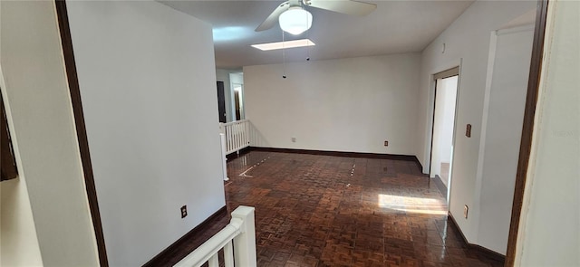 unfurnished room with ceiling fan and dark parquet floors