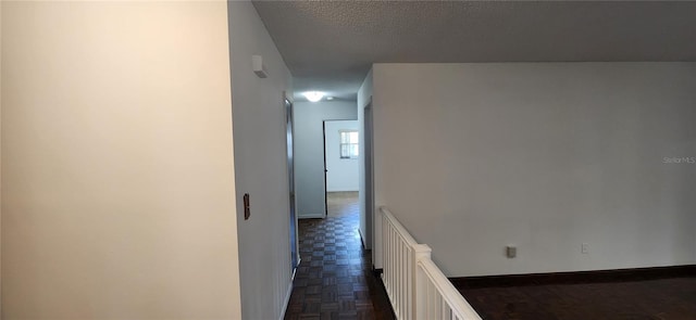 hallway featuring dark parquet floors and a textured ceiling