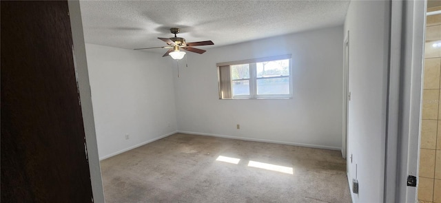 empty room featuring a textured ceiling, light colored carpet, and ceiling fan