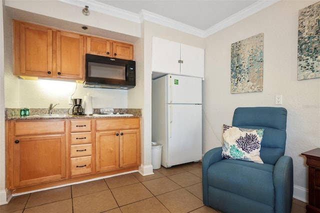 kitchen featuring crown molding, freestanding refrigerator, a sink, black microwave, and tile patterned floors