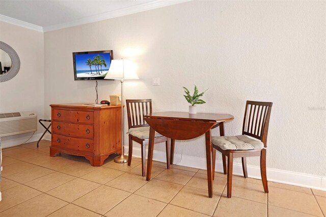 sitting room with light tile patterned flooring, crown molding, and baseboards