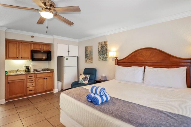 bedroom with light tile patterned floors, ceiling fan, ornamental molding, freestanding refrigerator, and a sink