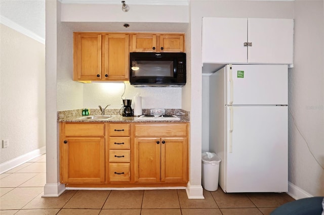 kitchen with white appliances, light tile patterned floors, baseboards, and a sink