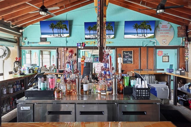 bar with a dry bar, ceiling fan, and vaulted ceiling