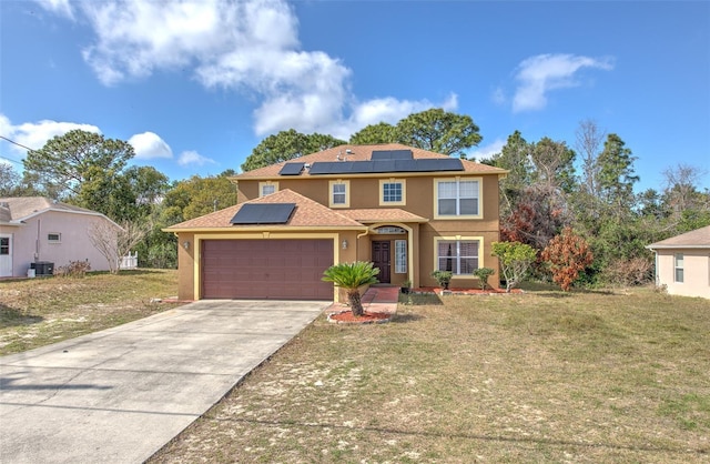 view of front of home featuring a garage, solar panels, central air condition unit, and a front lawn