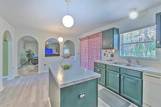 kitchen featuring sink, decorative light fixtures, a center island, white dishwasher, and light hardwood / wood-style floors