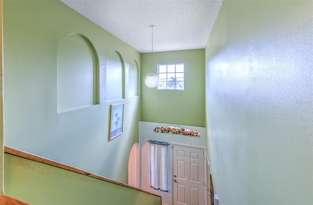 stairway with a textured ceiling