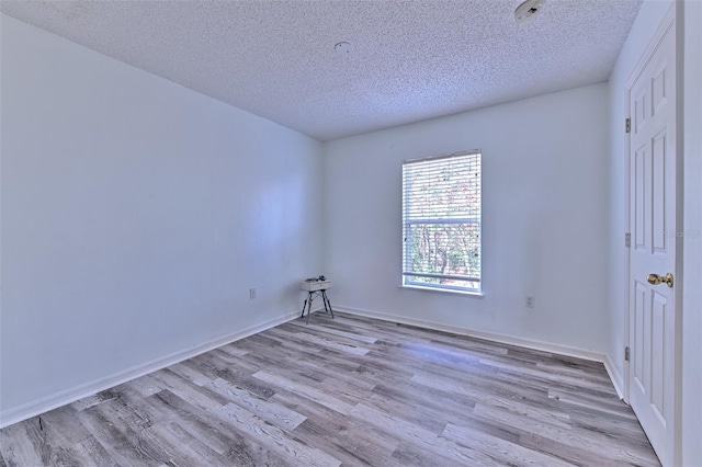 unfurnished room with light hardwood / wood-style floors and a textured ceiling