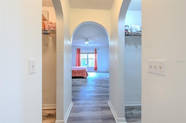 hall featuring wood-type flooring and a textured ceiling