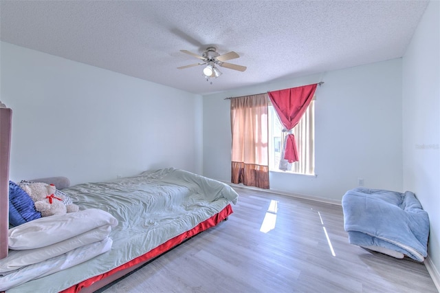 bedroom featuring wood-type flooring, a textured ceiling, and ceiling fan