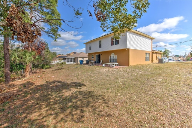 back of house featuring cooling unit and a yard