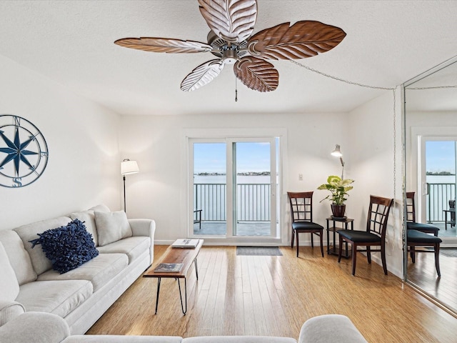 living room featuring a textured ceiling, ceiling fan, hardwood / wood-style floors, and plenty of natural light