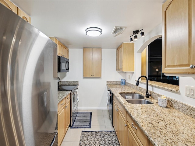 kitchen featuring light stone counters, sink, light tile patterned floors, appliances with stainless steel finishes, and light brown cabinets