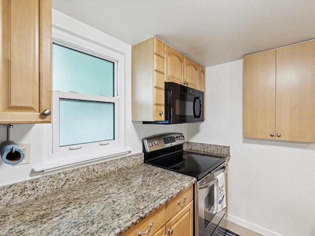 kitchen featuring electric range, light brown cabinetry, and light stone counters