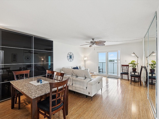 dining space with wood-type flooring and ceiling fan