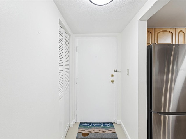 doorway to outside with a textured ceiling