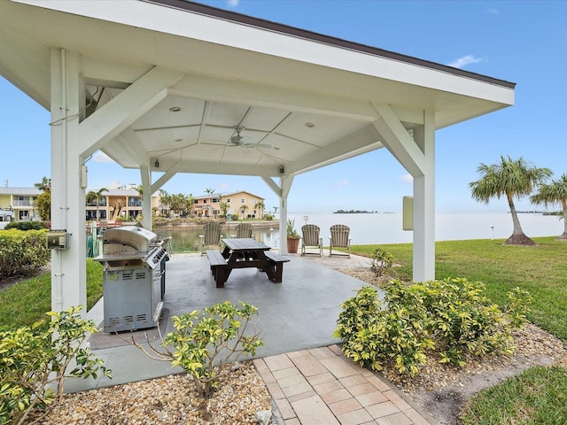 view of property's community with a gazebo, a patio, a lawn, and a water view