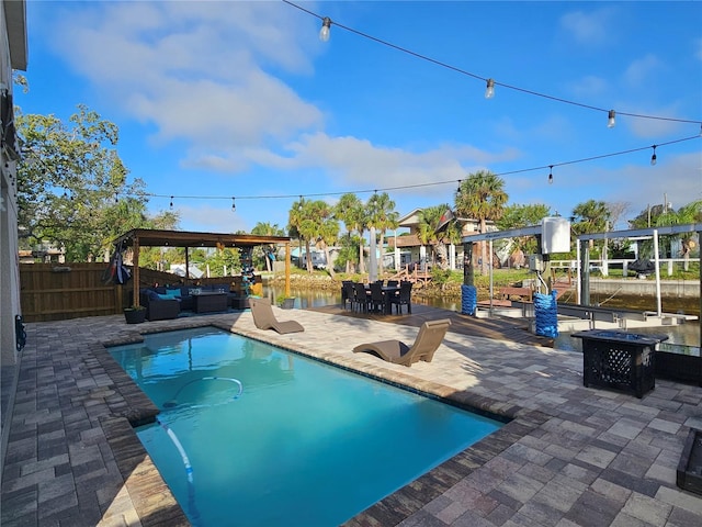 view of swimming pool featuring a water view and a patio