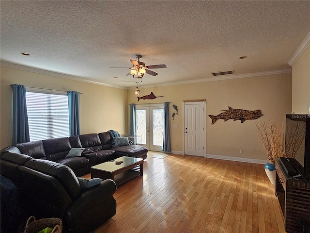 living room with french doors, ceiling fan, ornamental molding, a textured ceiling, and light hardwood / wood-style floors