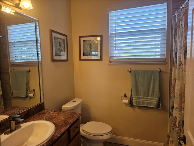 bathroom with a shower with shower curtain, tile patterned floors, vanity, and toilet