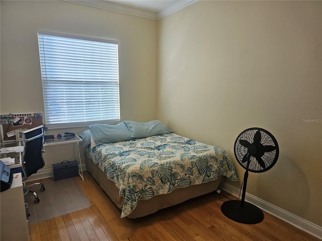 bedroom featuring multiple windows, crown molding, and hardwood / wood-style floors