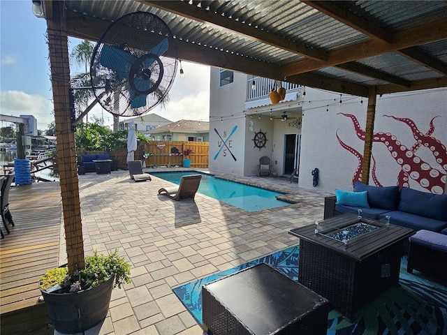 view of swimming pool featuring an outdoor living space with a fire pit and a patio