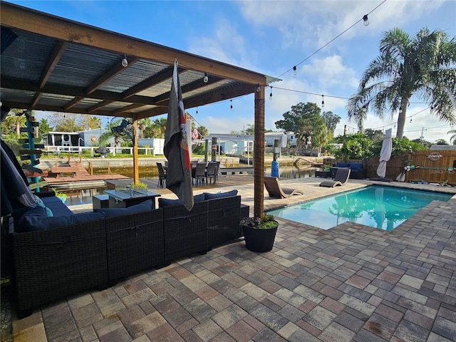 view of pool featuring a patio area, a water view, and an outdoor hangout area