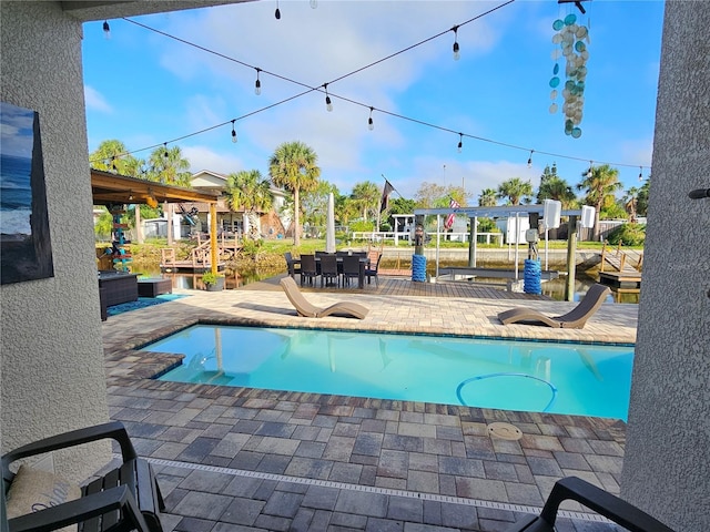 view of swimming pool featuring a patio area and a water view