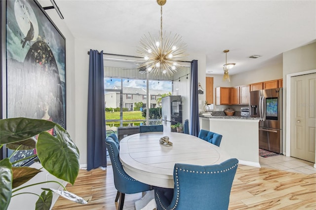 dining area featuring light hardwood / wood-style floors and a notable chandelier