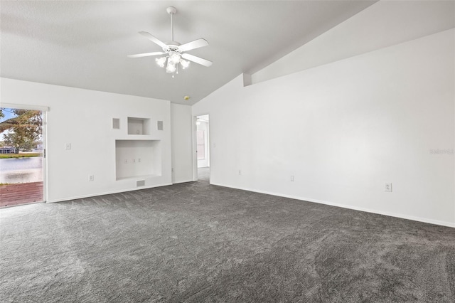 unfurnished living room with dark colored carpet, ceiling fan, and lofted ceiling