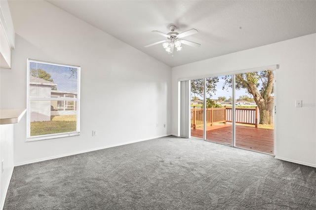 carpeted empty room featuring vaulted ceiling and ceiling fan