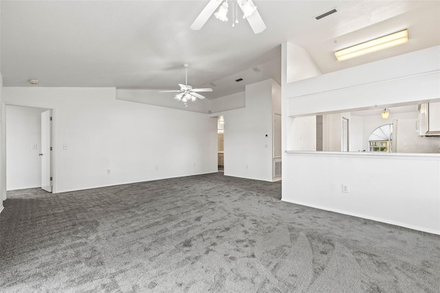 unfurnished living room with dark colored carpet, vaulted ceiling, and ceiling fan