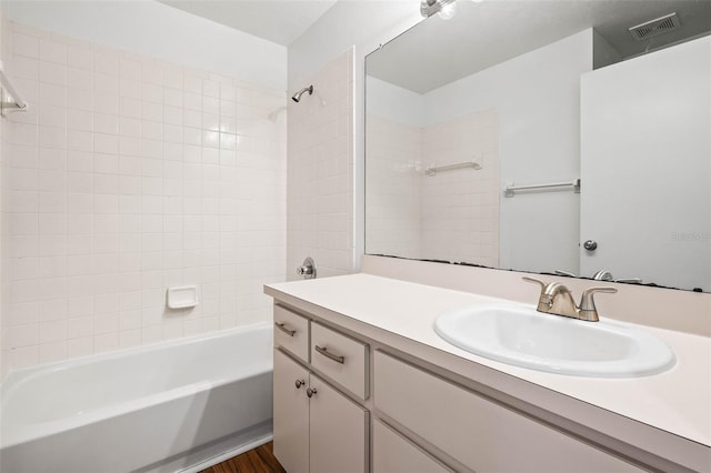 bathroom featuring vanity, tiled shower / bath combo, and hardwood / wood-style flooring