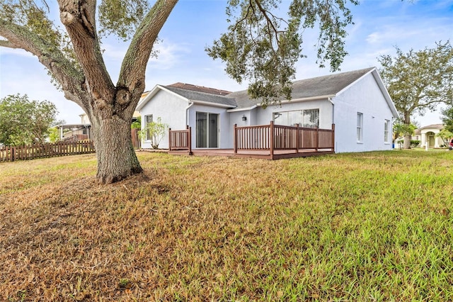 rear view of property with a lawn and a wooden deck