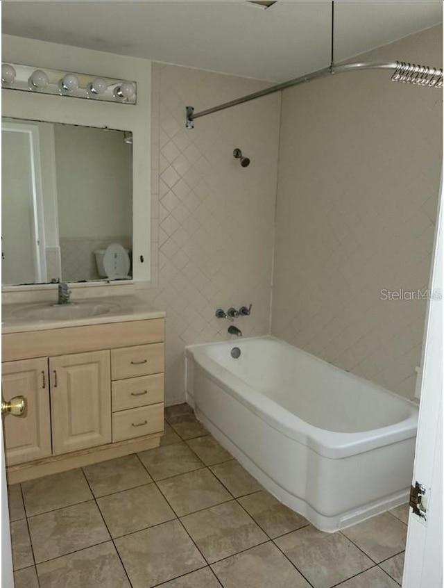 bathroom with tile patterned flooring, vanity, and tiled shower / bath