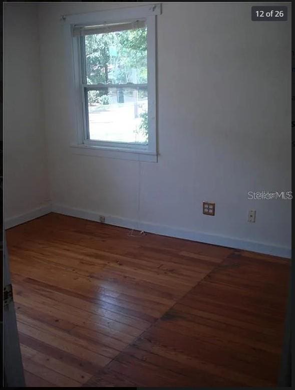 spare room with dark hardwood / wood-style flooring